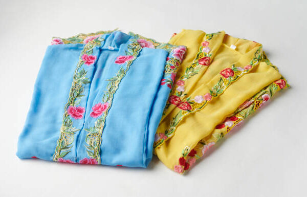 Close-up details shot of traditional yellow and blue kebaya dress. Nyonya kebaya in selective focus.